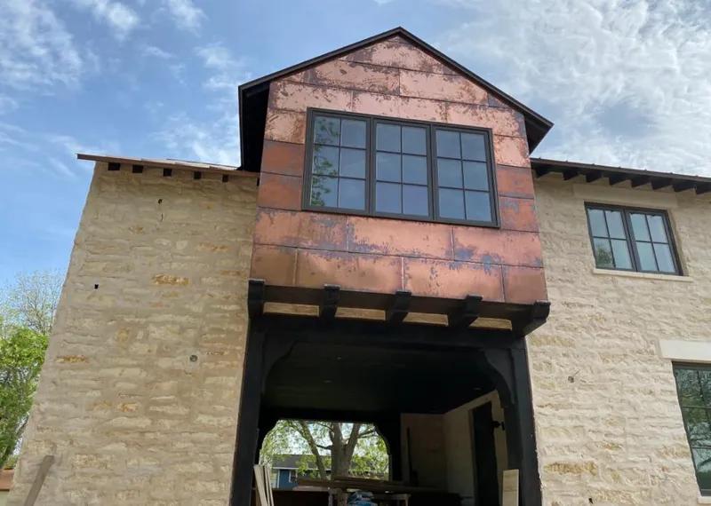 Copper metal panel facade on a stone building for Roof Repair in Dorr